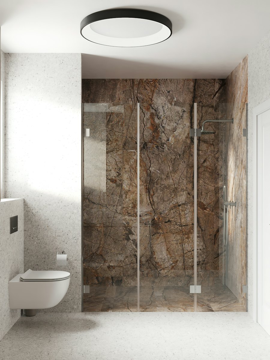 Baño con mampara de vidrio y muro de mármol, vidriería en Chile